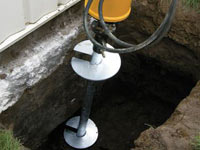 Installing a helical pier system in the earth around a foundation in Florissant