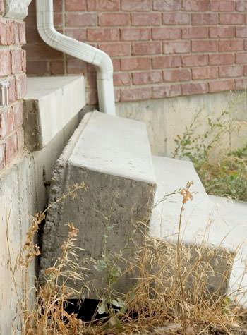 sinking outdoor concrete steps showing cracking and soil washout in Collinsville