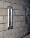 an inside view of foundation wall anchors installed along a basement wall to brace and repair the structure in Urbana